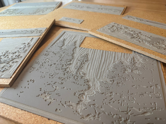 Linoleum prints with images on a wooden background.