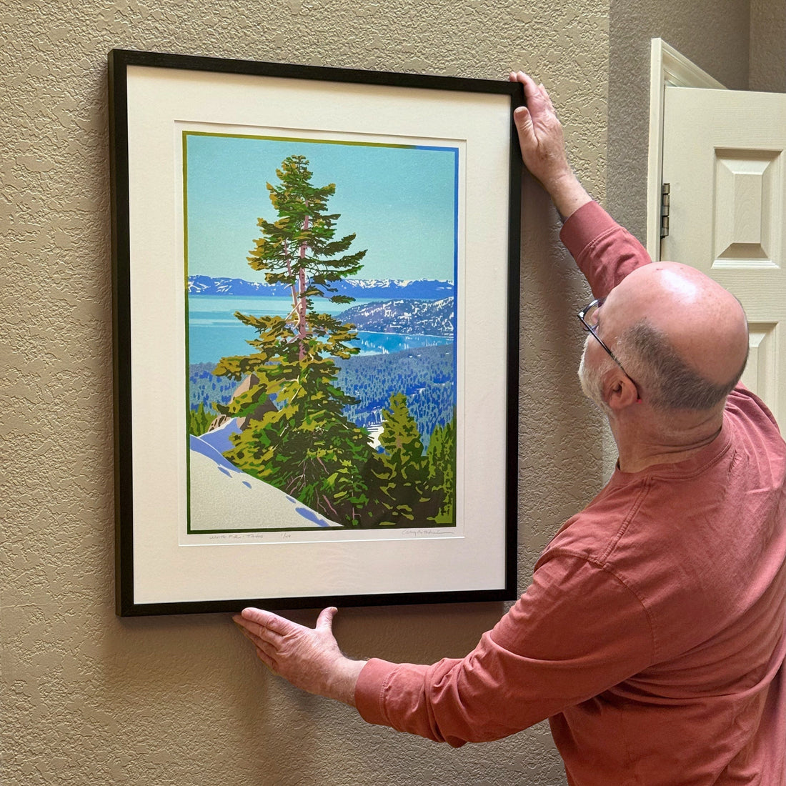 Craig Mitchell hanging original Lake Tahoe art on wall