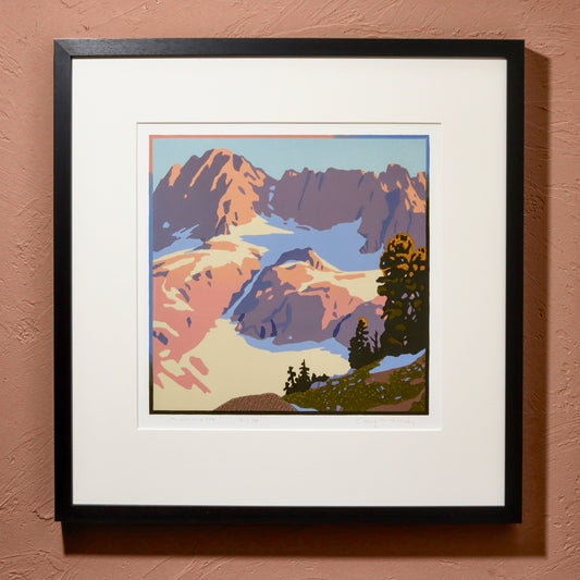 A framed art print titled 'Mammoth', featuring a mountain landscape with pink and purple hues, displayed in a black frame.