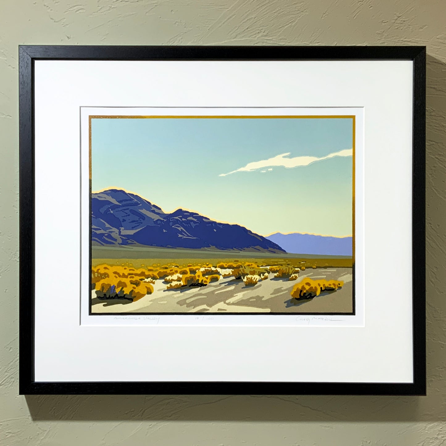 A framed art print of Amargosa Valley looking southwest into Death Valley, featuring a mountain range in the background and a golden landscape in the foreground.