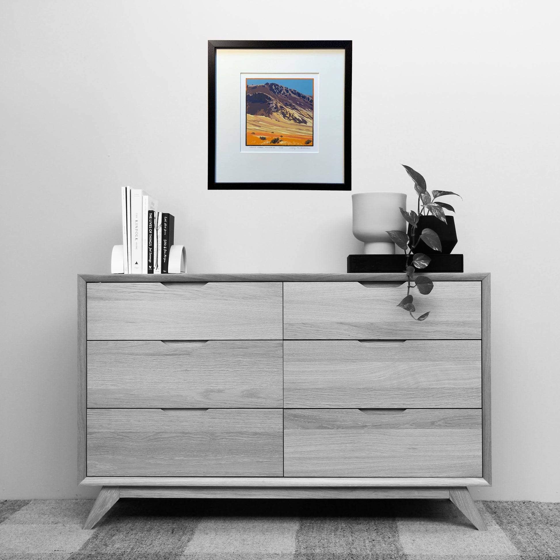 Artwork of Trout Creek mountains shown matted and framed over dresser for scale